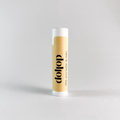 Lip balm with 'dollop' branding on a light gray background